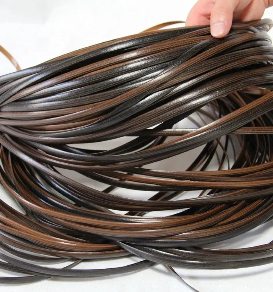 A bundle of premium rattan wicker repair strips in dark brown and black leather neatly coiled for decoration and repair