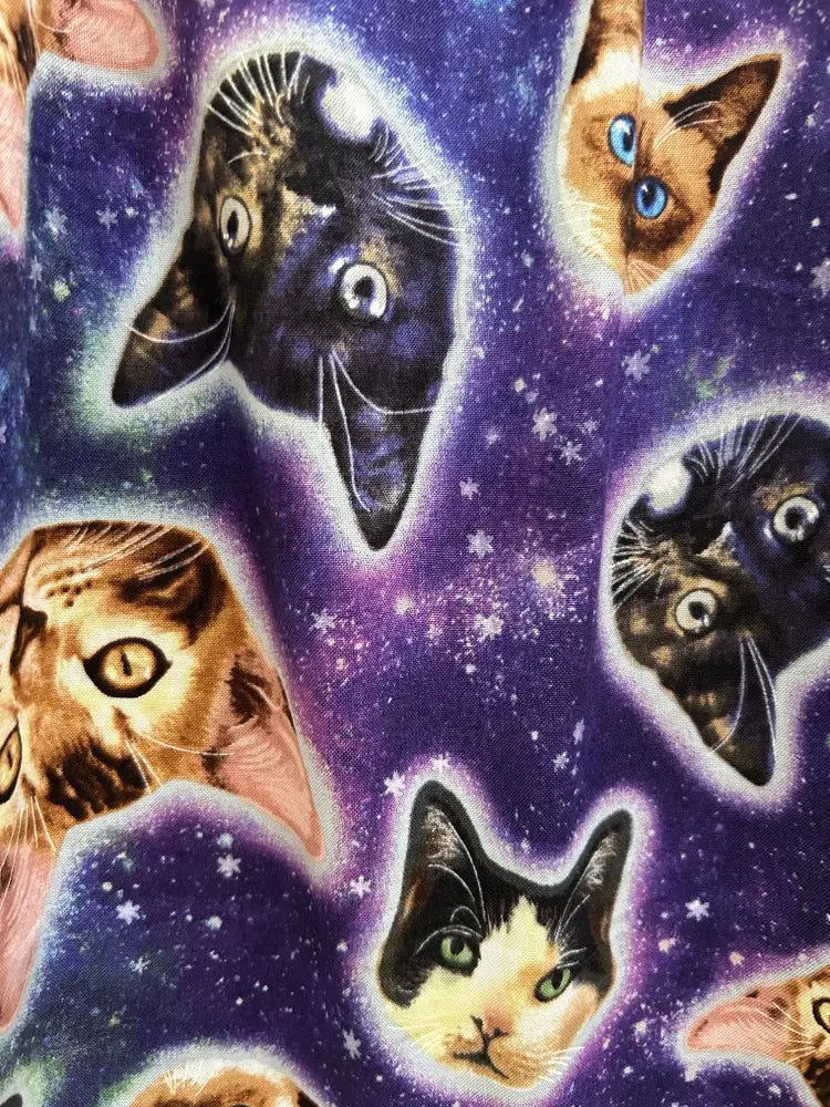 Purple fit and flare cotton dress featuring galaxy cats pattern with cartoon cat faces on a starry space background