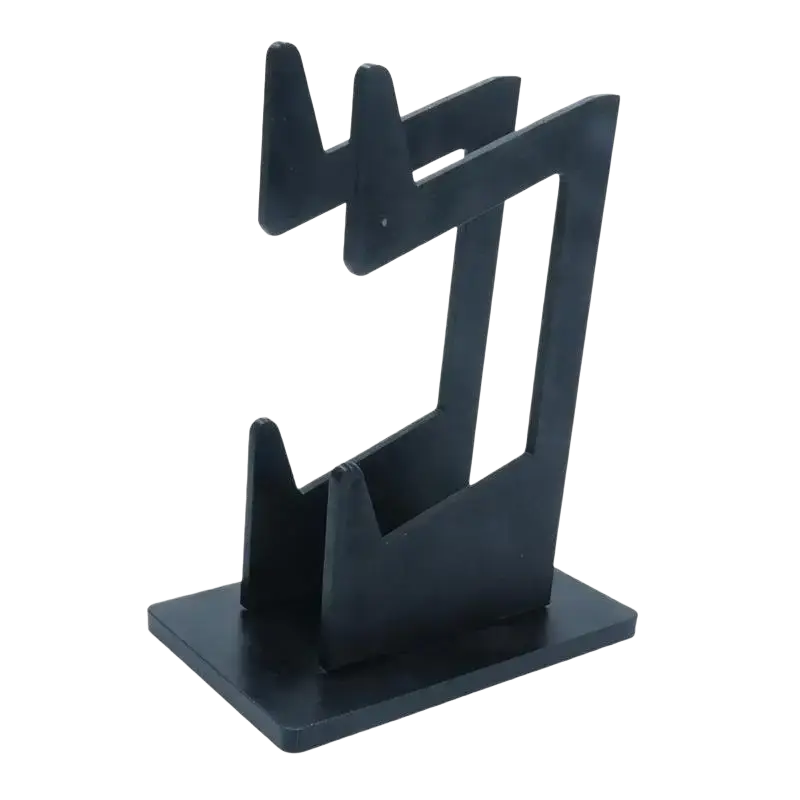 The picture shows a black plastic game controller holder with a minimalist geometric design and two angled slots