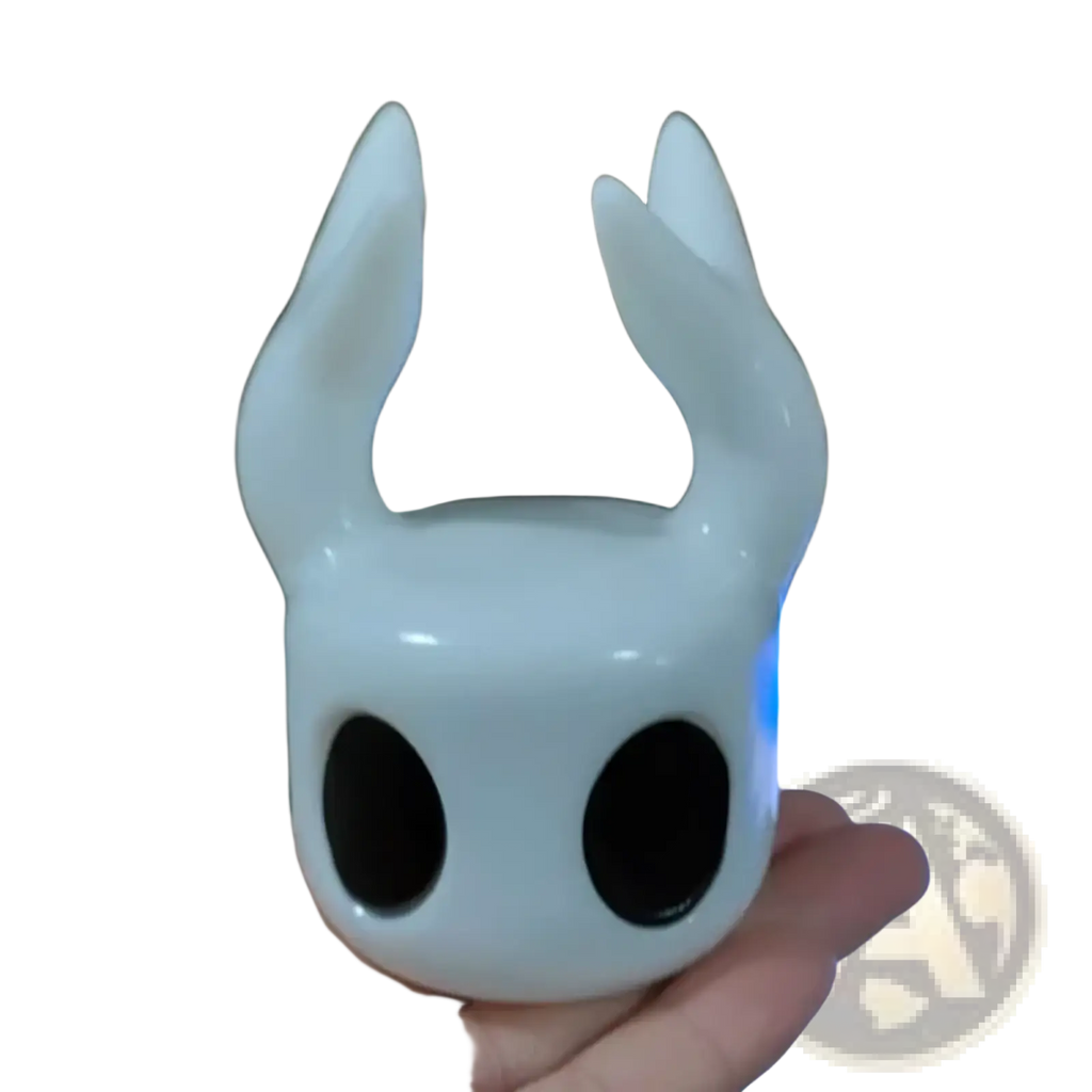 Glossy white ceramic hollow knight figurine with black eyes and horn-like protrusions game controller stand display