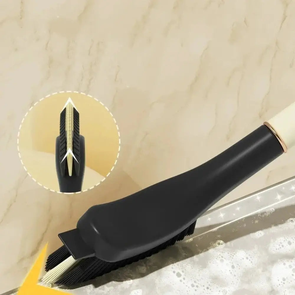 Black plastic scrub brush with gold metal accents and white handle featuring dense bristles for cleaning sinks and countertops