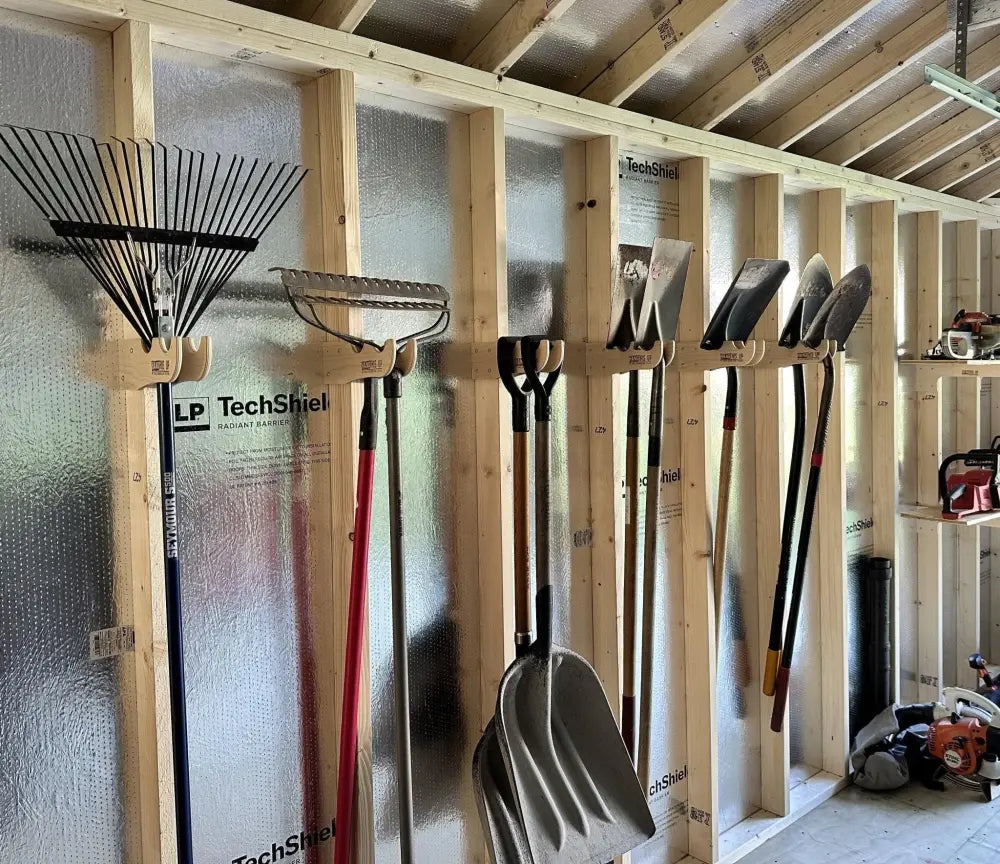 Wooden garden tool organizer with stud mounted wave design holding shovels rakes and trowels on a wooden rack