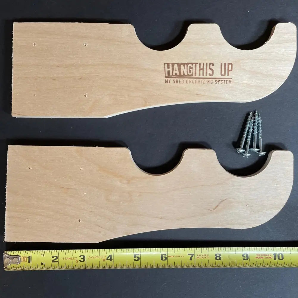 Light-colored wooden shed wall organizers with curved wave design and engraved hang this up my shed organizing system text