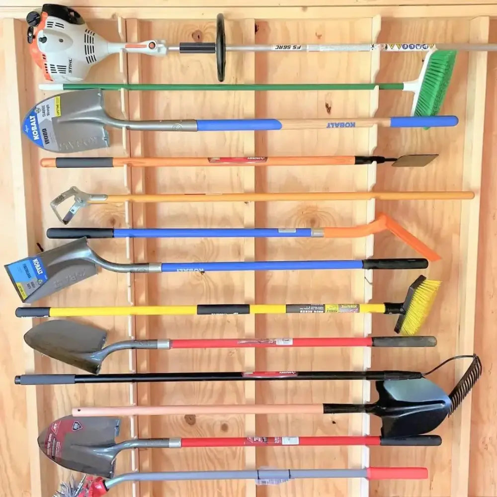 A birch wood stud mounted garden tool organizer rack with colorful shovels and string trimmer neatly arranged