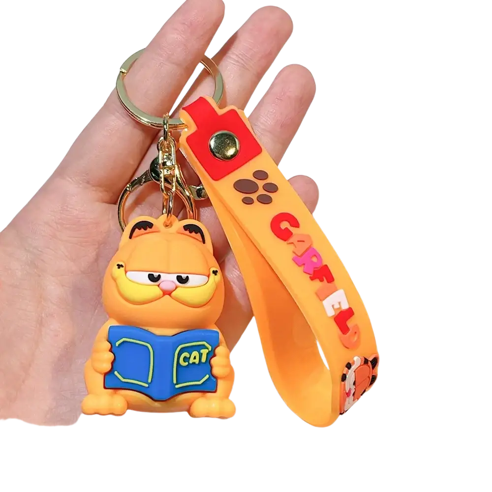 Orange Garfield rubber keychain with blue book and red wrist strap featuring anime cat key pendant design