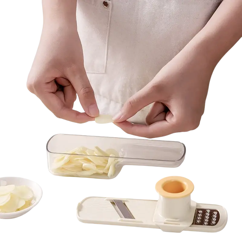 Cream-colored plastic garlic grinder with stainless steel blade and orange handle for efficient garlic grinding