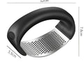 Black-handled stainless steel garlic press with curved perforated grating surface ergonomic manual mincer tool