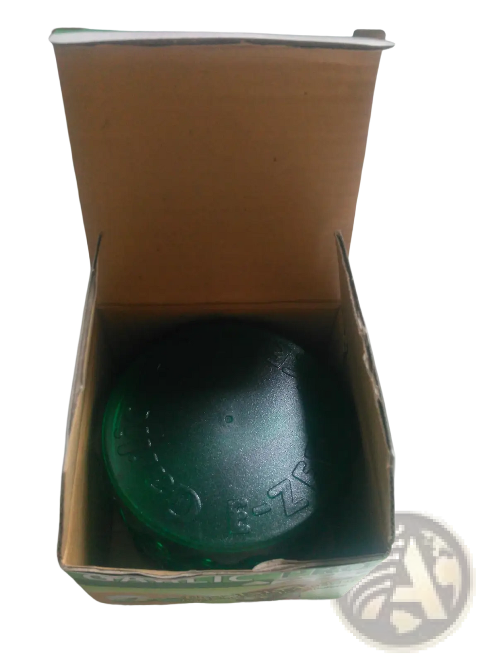 A dark green textured soap bar in a cardboard box next to the garlic pro manual grinder and peeler kitchen tool
