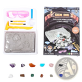 The gem dig kit kids stem geology toy includes a gray sand tray with crystal molds, pink goggles, yellow tools, and 12 real gemstones