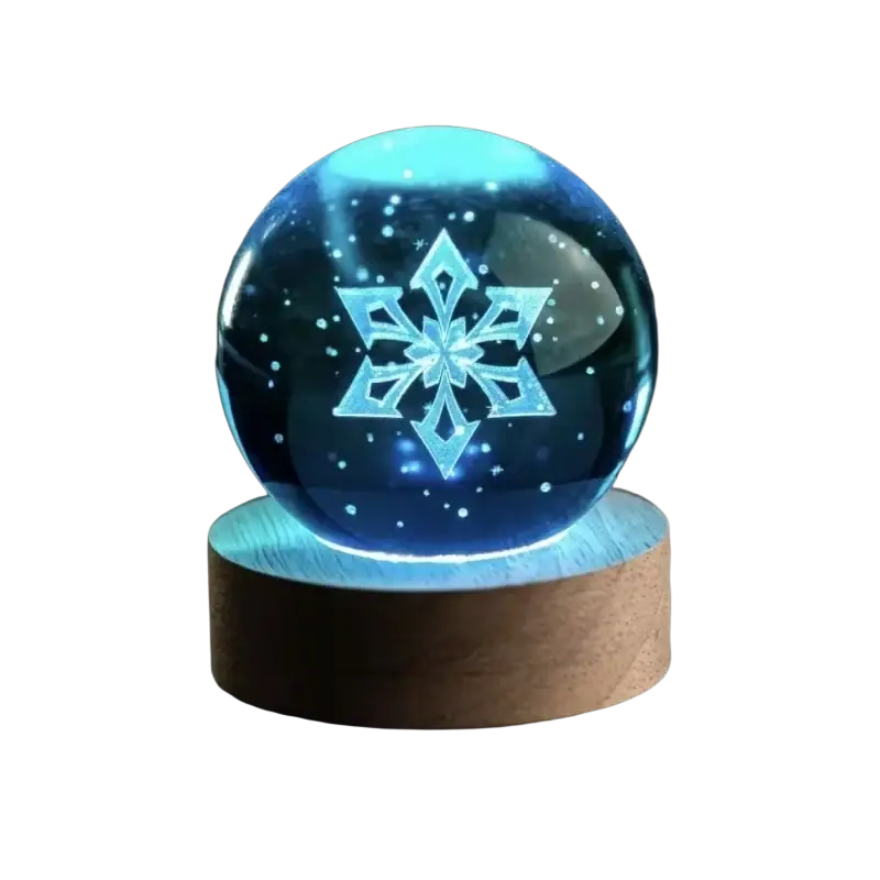 A glowing blue snowflake design illuminated inside a clear 6 cm crystal ball on a wooden base finished goods