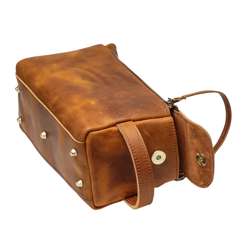 Genuine leather brown toiletry bag with brass studs size 26x15x11cm featuring pocket interior and matching handle