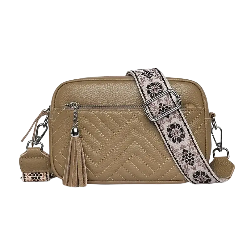 Tan genuine leather quilted crossbody bag with floral-patterned strap and tassel detail for versatile use