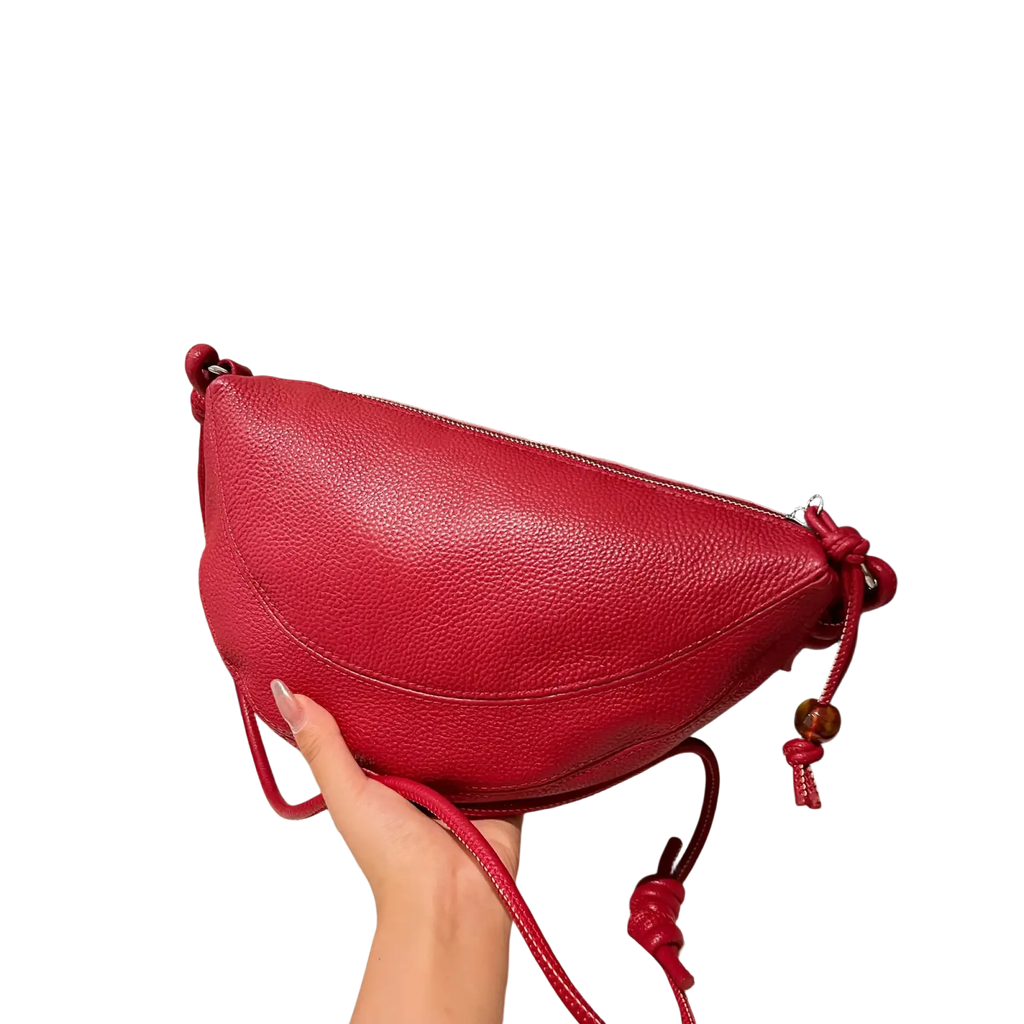 A vibrant red genuine leather crescent crossbody shoulder bag with knotted strap and wooden bead accents