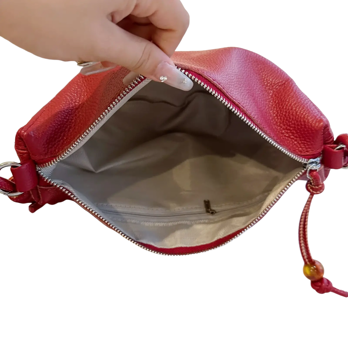 A vibrant red genuine leather shoulder bag with silver zipper and decorative beads in crescent crossbody style
