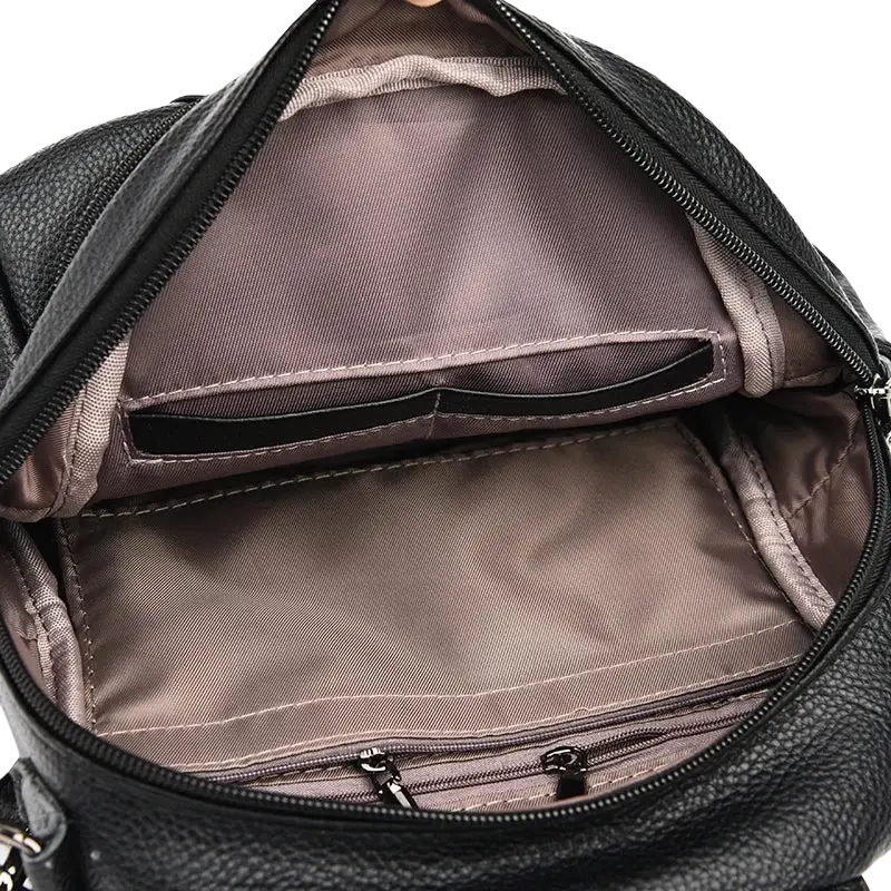 Genuine leather women travel backpack in black with gray pocket interior and multiple zippered compartments