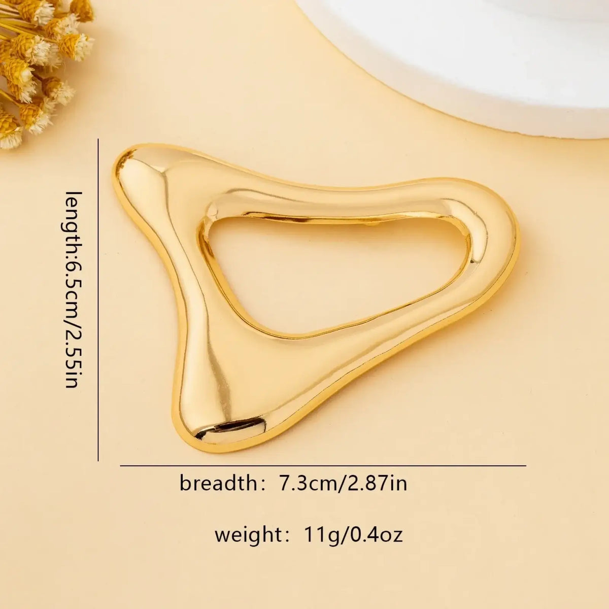 Gold-colored smooth polished jade massage tool with sleek ergonomic triangular shape for modern office use