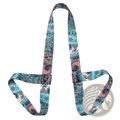 A vibrant teal and coral paisley-patterned yoga mat carry strap made of soft flexible fabric