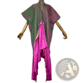A vibrant asymmetrical winyi poncho with green and pink polka dots frayed edges and a bold magenta panel