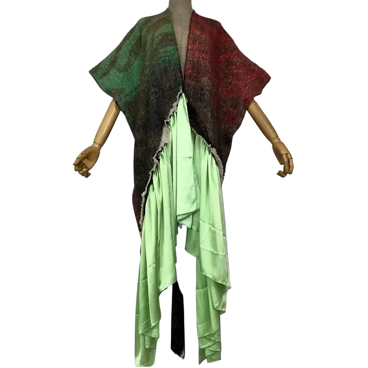 Winyi asymmetrical poncho with green and red textured knit top layered over light green satin skirt winter coat