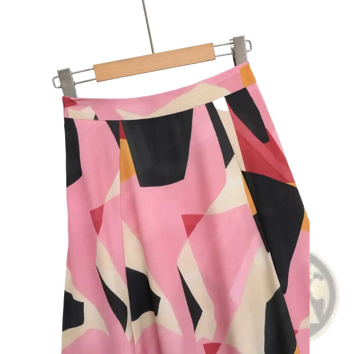 Geometric satin midi skirt in pink black and cream with an abstract geometric print hanging on a wooden hanger