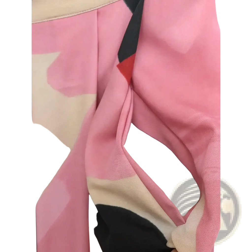 A soft pink beige and black abstract patterned scarf made of lightweight fabric styled with a geometric satin midi skirt
