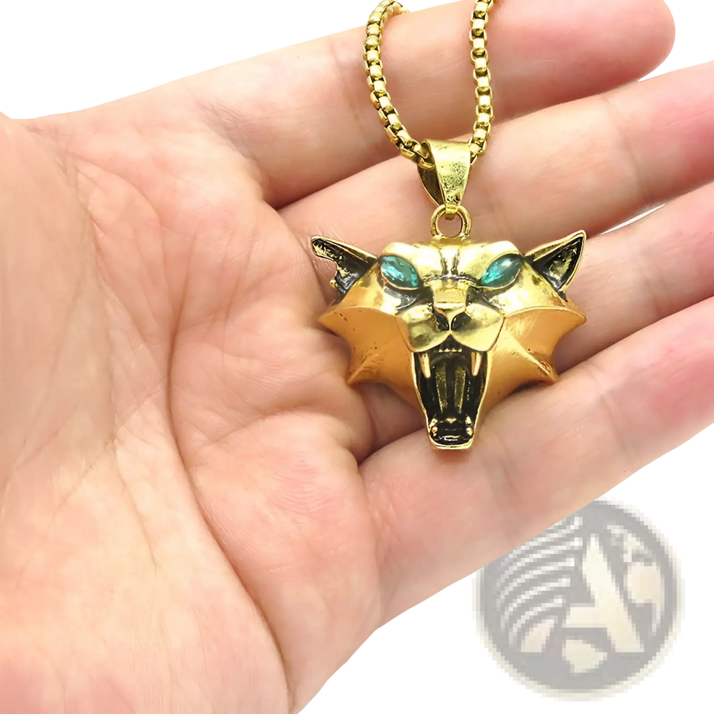 Gold-colored geometric wild game panther head pendant with teal gemstone eyes on a matching gold chain necklace