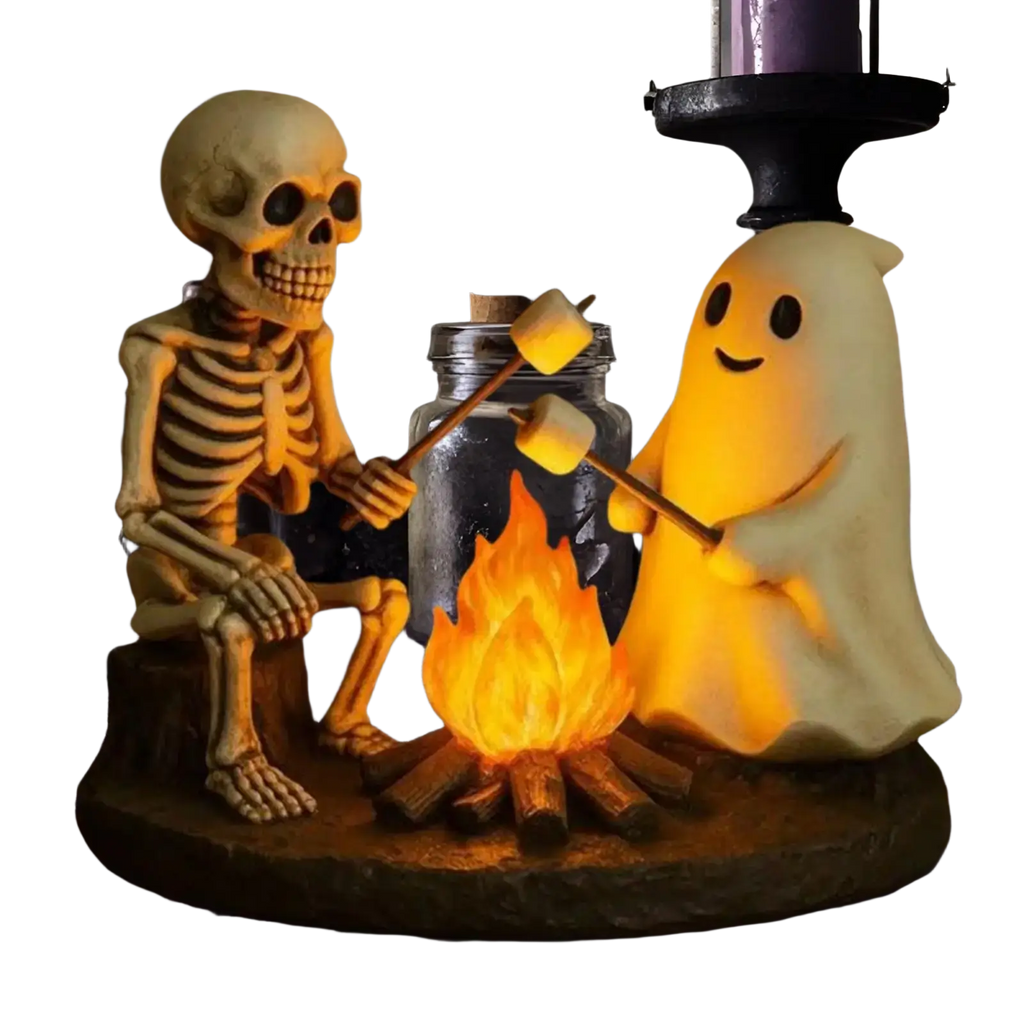 A glowing translucent yellow ghost bonfire night lamp with a smiling face beside a skeleton ghost figurine
