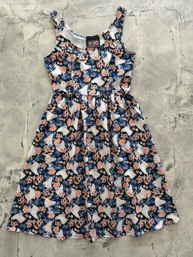 A navy blue sleeveless cotton midi dress with white unicorns pink and peach flowers and dark green foliage pattern