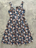 A navy blue sleeveless cotton midi dress with white unicorns pink and peach flowers and dark green foliage pattern
