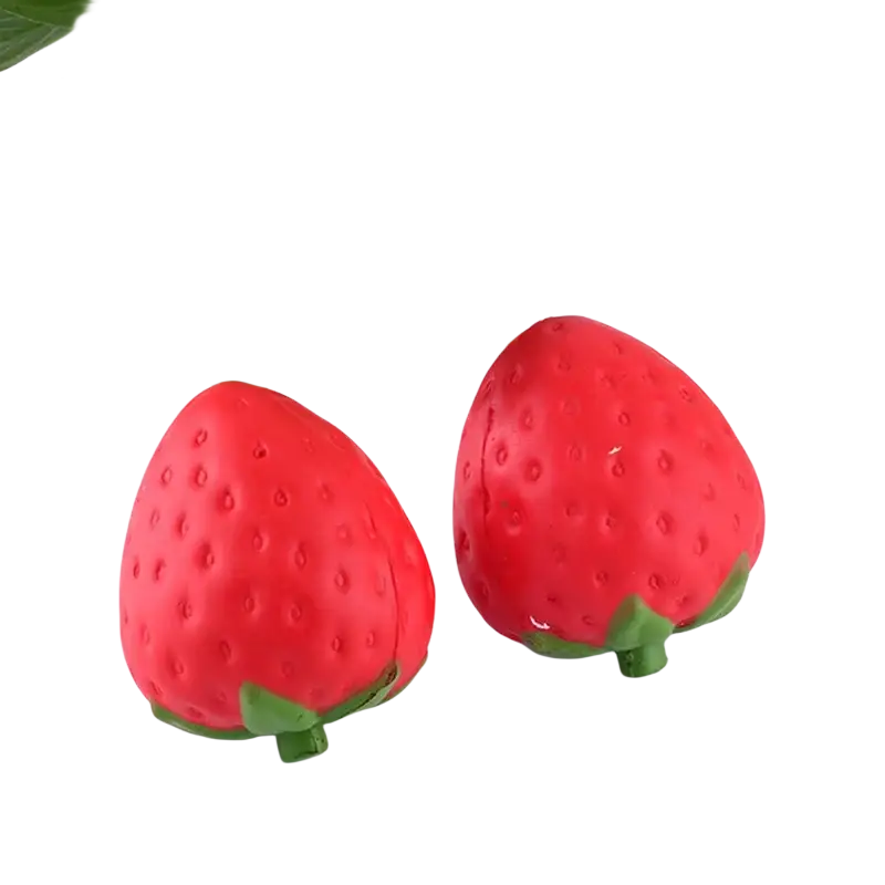 Giant strawberry slow rising squishy stress relief toy in red with green leafy tops and textured surfaces