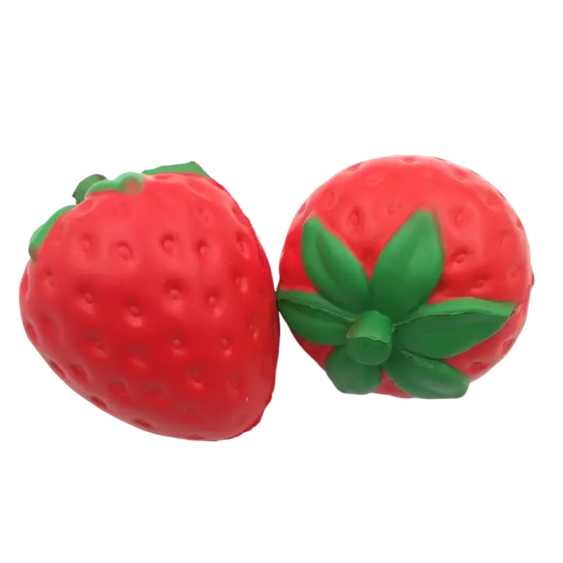 Giant strawberry slow rising squishy stress relief toy in red with green leafy top shaped like a strawberry stress ball