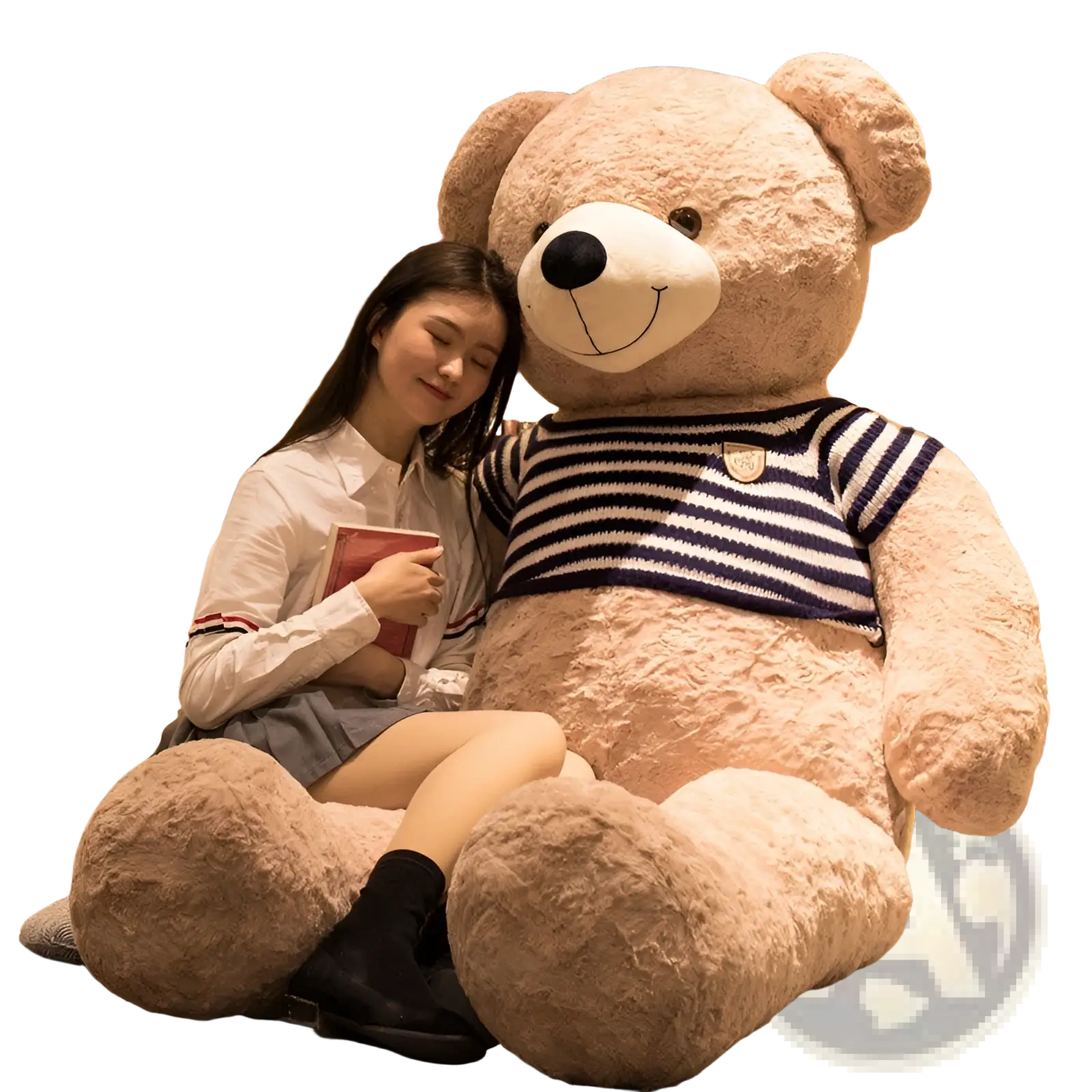 A plush tan giant teddy bear wearing a navy and white striped knit heart sweater