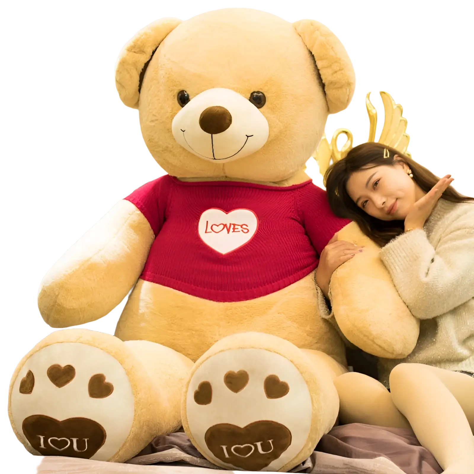 A plush tan giant teddy bear wearing a red knit heart sweater with brown paw prints on its feet saying i love you