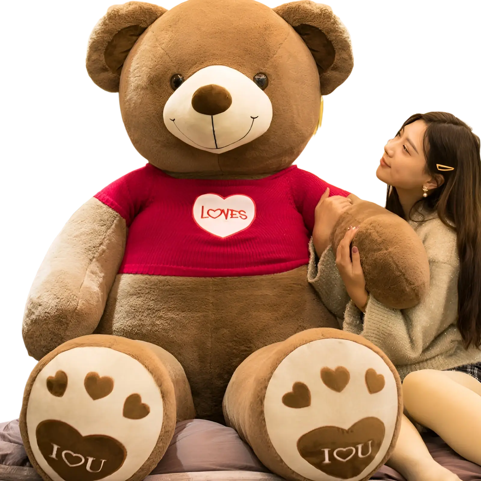 Giant plush brown teddy bear toy wearing a red knit heart sweater with paw prints on its feet