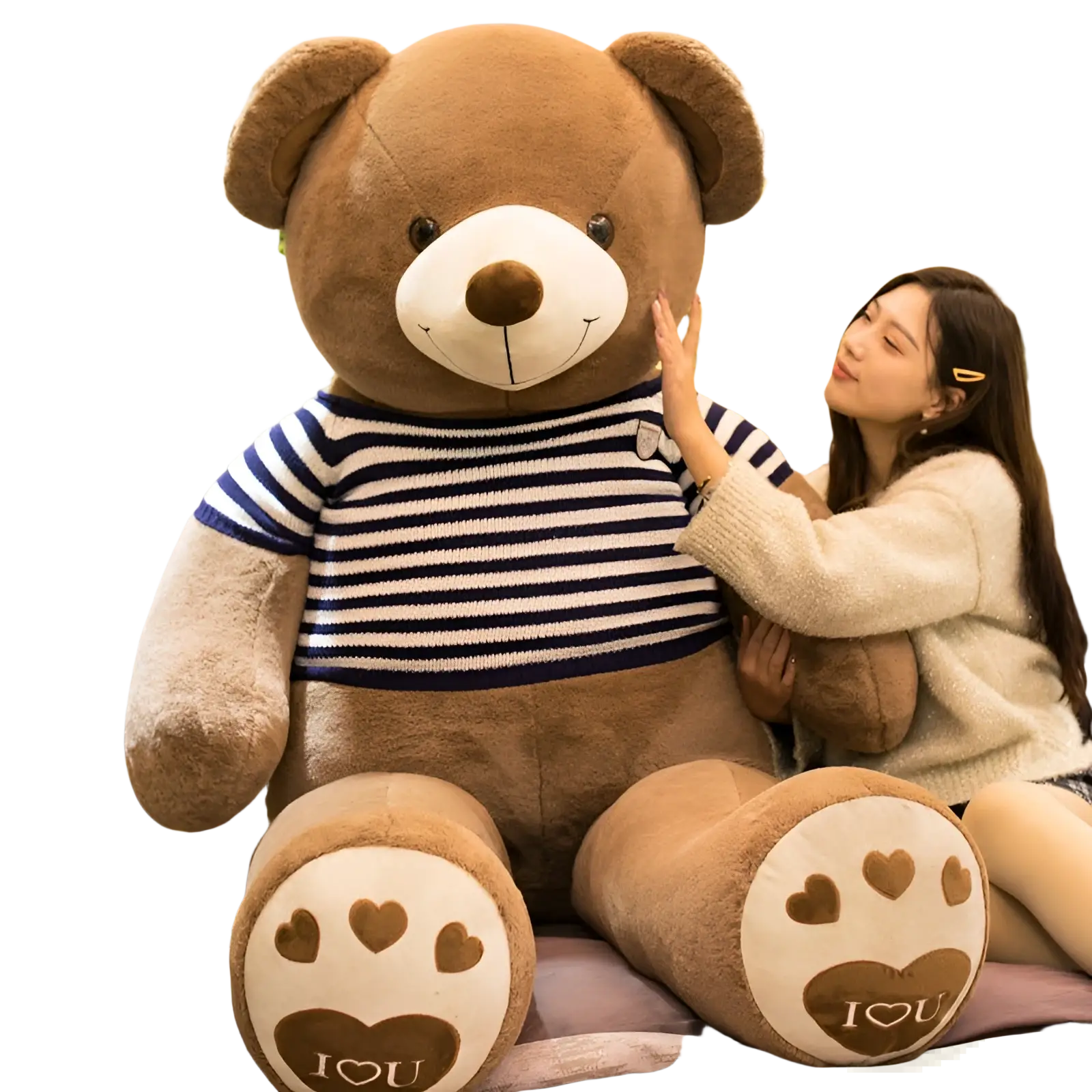 Giant plush brown teddy bear wearing a navy and white striped sweater with heart designs on its paws