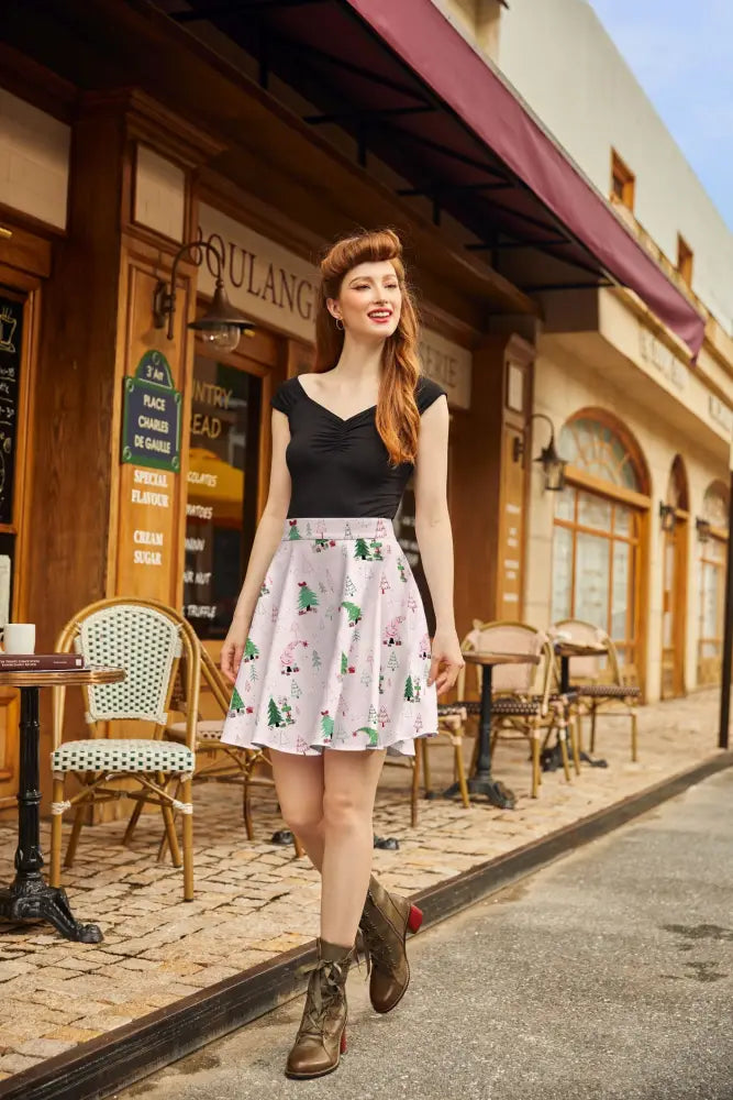 A festive pink holiday cotton skater skirt with green christmas trees red reindeer and a gathered waistband