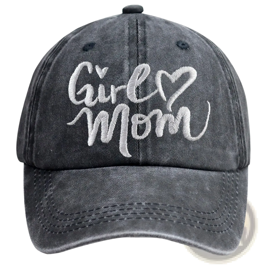 A dark gray distressed denim baseball cap with white embroidered girl mom text and heart accents, adjustable fit