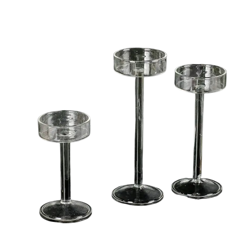Set of three clear glass pillar candle holders with slender stems and circular bases for modern table decor