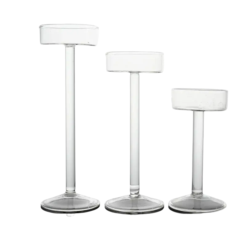 Three clear glass pillar candle holders with cylindrical tops and slender stems for modern table decor