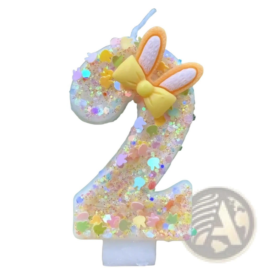 A glittery translucent number two birthday candle with yellow bow and bunny ears for festive celebrations
