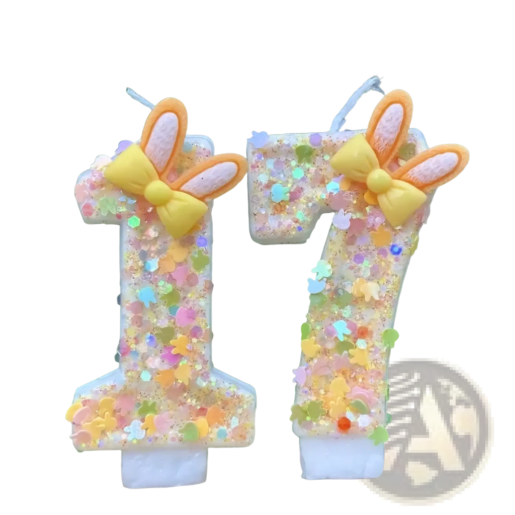Pastel-colored glitter bunny ear number birthday candles shaped as 1 and 7 with yellow bows