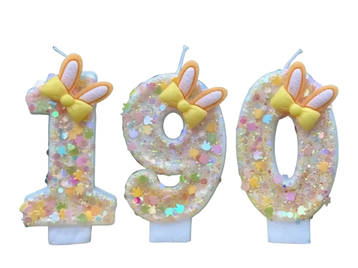 Pastel glittery number birthday candles shaped like 190 with yellow bows and orange bunny ears for decoration