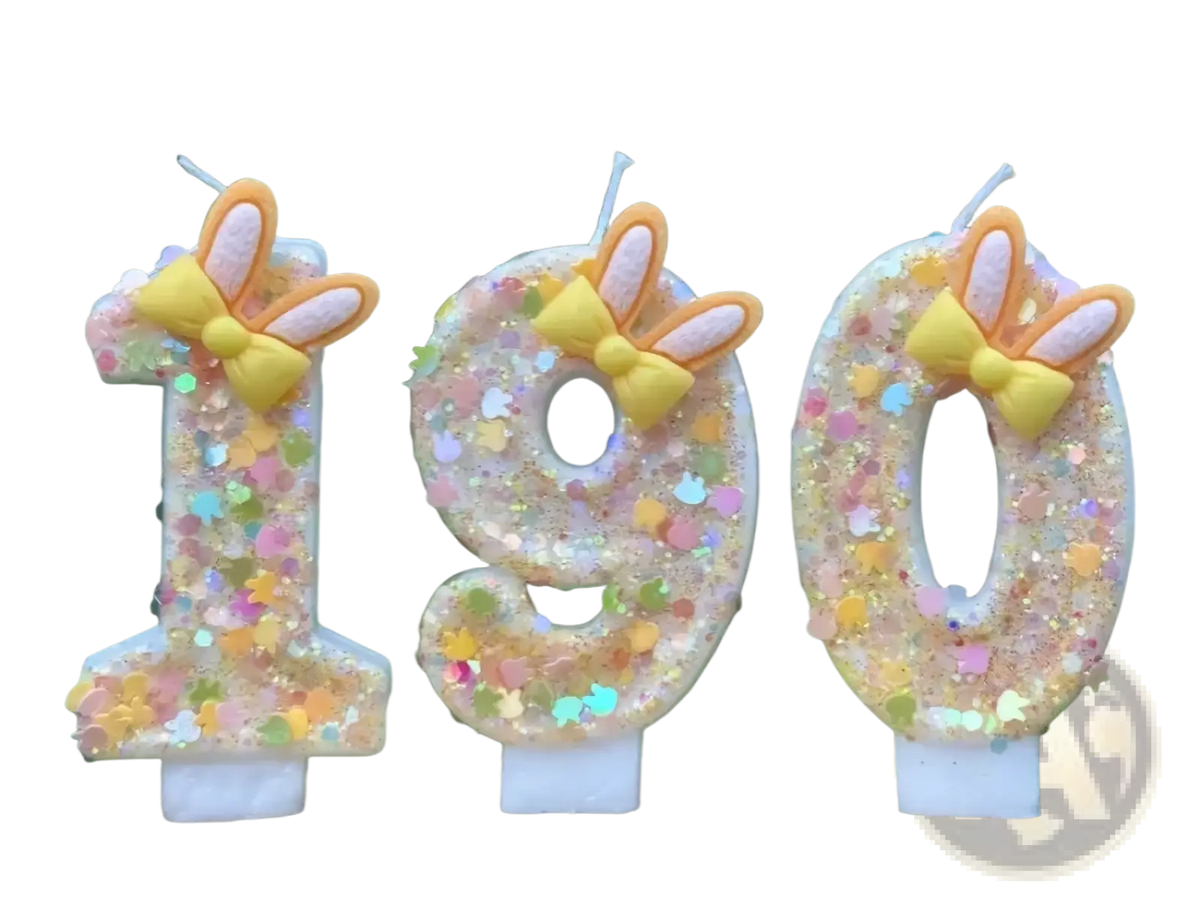 Pastel glittery number birthday candles shaped like 190 with yellow bows and orange bunny ears for decoration