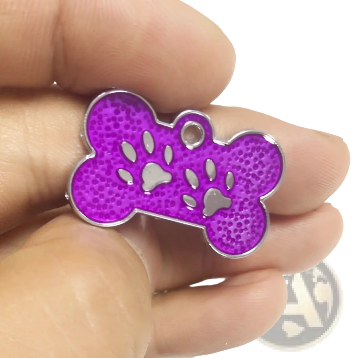 Purple bone-shaped glitter paw print metal dog tag with silver paw cutouts and a metallic border for pets