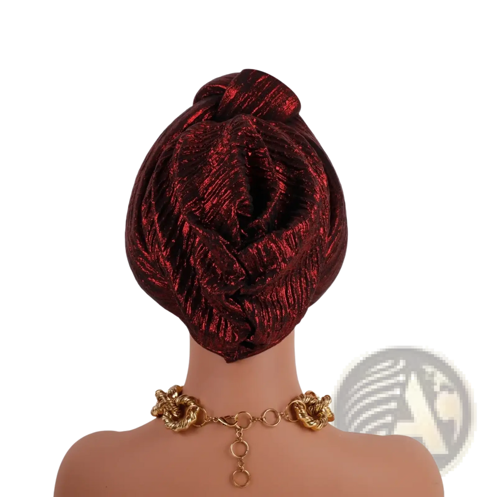A glitter turban headwrap for women in metallic burgundy textured shimmering fabric with an elegant knot for Nigerian weddings
