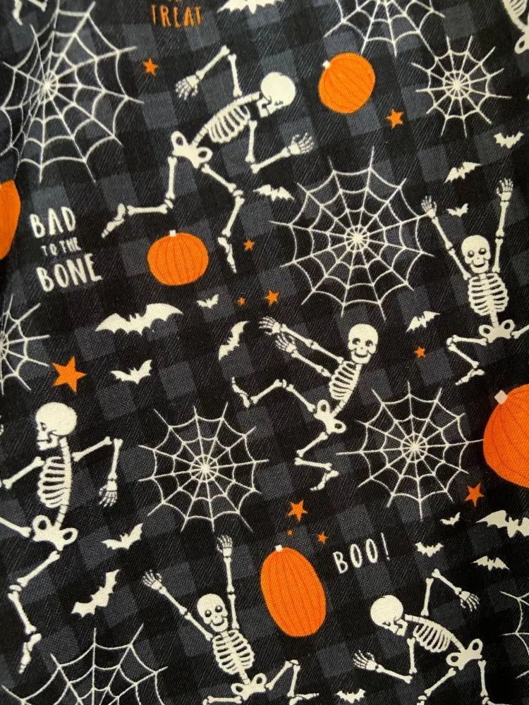 Black halloween-themed fabric with white skeletons orange pumpkins and spiderwebs for glow in the dark dancing skeleton skirt