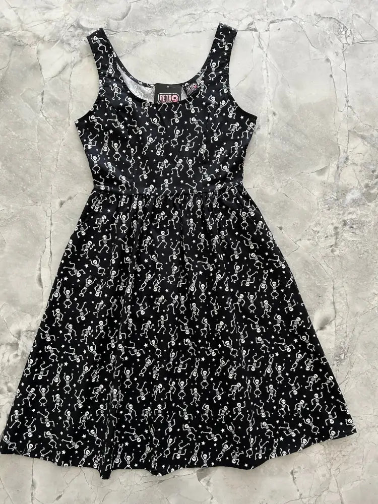 Black sleeveless fit and flare dress with glow in the dark white dancing skeletons and stars pattern