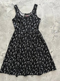 Black sleeveless fit and flare dress with glow in the dark white dancing skeletons and stars pattern