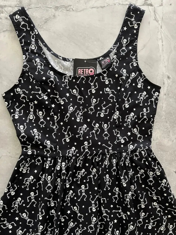 Black sleeveless fit and flare dress with glow in the dark white dancing skeleton and star print, scoop neckline, gathered waist