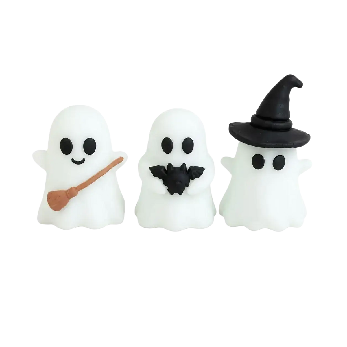 Three white glowing halloween ghost desktop decor figurines with black eyes smiles holding broomstick bat and witch hat